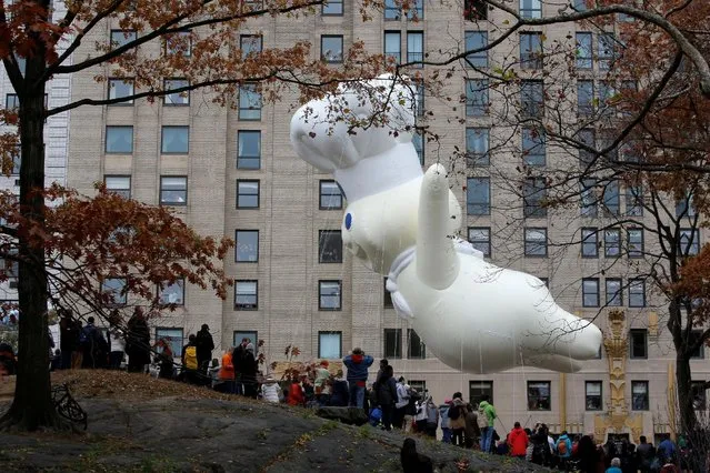 People watch from Central Park as the Pillsbury Doughboy  makes it's way down West 59th Street during the 90th Macy's Thanksgiving Day Parade in Manhattan, New York, U.S., November 24, 2016. (Photo by Andrew Kelly/Reuters)