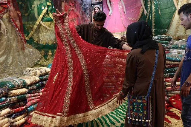 Afghan people buy clothes ahead of the Muslim Festival of Eid al-Fitr, to mark the end of Ramadan, in Herat, Afghanistan, 13 June 2018. Muslims around the world are preparing to celebrate Eid al-Fitr, the three day festival marking the end of the Muslim holy month of Ramadan, it will be observed on 15th or 16th of June depending on the lunar calendar. Eid al-Fitr is one of the two major holidays in Islam. (Photo by Jalil Rezayee/EPA/EFE/Rex Features/Shutterstock)