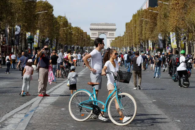 People ride bicycles, monowheel and walk as they enjoy a vehicle- free day in front of the Arc de Triomphe (Triumphal arch) in Paris, on September 16, 2018. Europe should hold an annual car- free day in a bid to ease air pollution, the mayors of Paris and Brussels said on September 15, 2018 on the eve of a vehicle- free day in their cities. (Photo by Francois Guillot/AFP Photo)