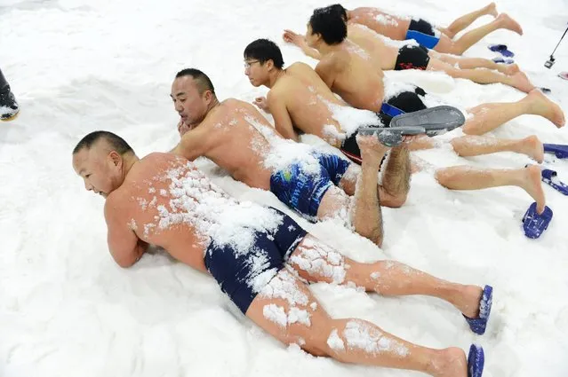 Contestants lie on artificial snow during a cold enduring competition in temperature of negative 6 degrees Celsius (21.2 degrees Fahrenheit), at an indoor ski resort in Changsha, Hunan province, January 19, 2016. (Photo by Reuters/China Daily)