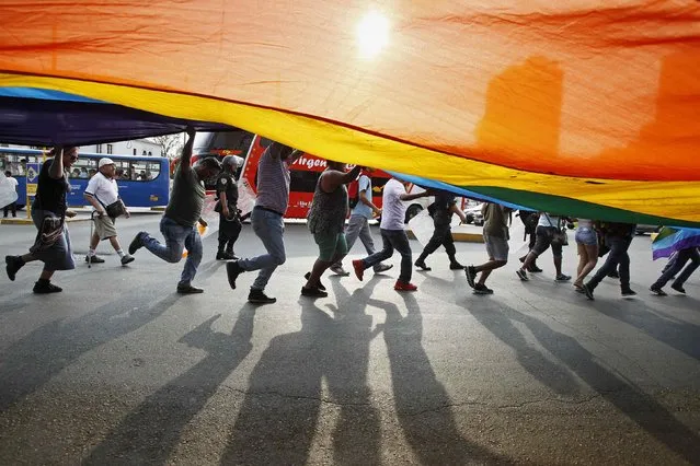 Members of gay and lesbian organizations hold a Gay Pride flag as they march in support of the Civil Union project law in Lima, March 7, 2015.    REUTERS/Enrique Castro-Mendivil (PERU - Tags: POLITICS SOCIETY)