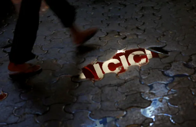 ICICI bank signboard is reflected in a puddle on a street in New Delhi, India, March 5, 2016. (Photo by Adnan Abidi/Reuters)