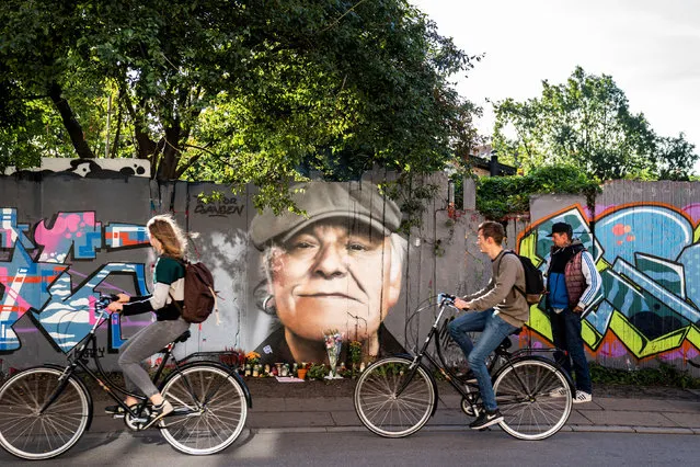 Tributes are laid to the singer Kim Larsen, who died over the weekend aged 72, in front of a portrait painted on a fence in Christiania, Copenhagen, Denmark on September 30, 2018. (Photo by Martin Sylvest/Scanpix/Reuters)