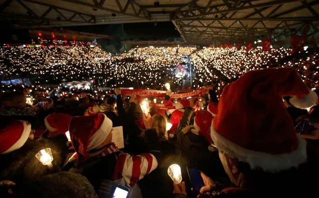 People attend the “Weihnachtssingen”, a candle-lit carol concert with 28500 fans of the second-division club FC Union Berlin at the Alte Foersterei stadium in Berlin, Germany, December 23, 2016. (Photo by Hannibal Hanschke/Reuters)
