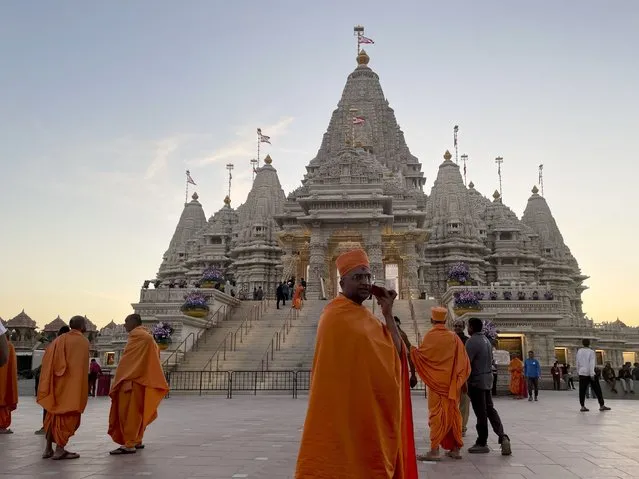 Monks in saffron robes walk in front of the BAPS Swaminarayan Akshardham, the largest Hindu temple outside India in the modern era, on Wednesday October 4, 2023, in Robbinsville, N.J. The temple was partly built using marble from Italy and limestone from Bulgaria hand-carved by artisans in India and shipped to New Jersey. (Photo by Luis Andres Henao/AP Photo)