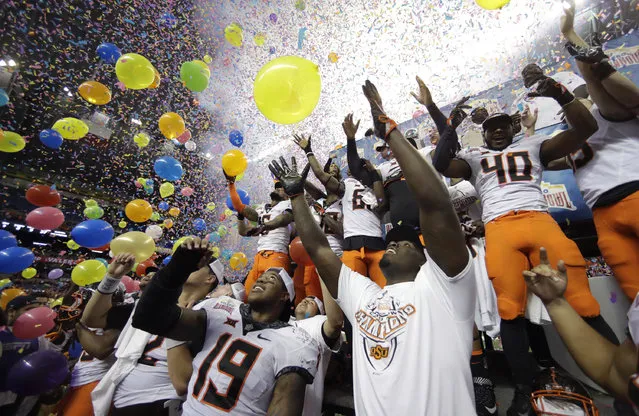 Oklahoma State players celebrate the team's 38-8 win over Colorado in the Alamo Bowl NCAA college football game, Thursday, December 29, 2016, in San Antonio. (Photo by Eric Gay/AP Photo)