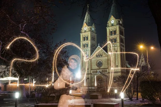 A young woman writes '2017' using a sparkler during the New Year's Eve celebrations in Nyiregyhaza, 245 kms east of Budapest, Hungary, Saturday, December 31, 2016. (Photo by Attila Balazs/MTI via AP Photo)