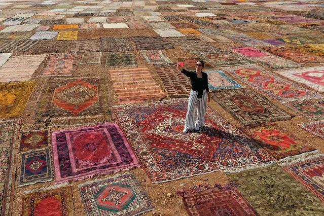 A drone photo shows a view of hand knotted carpets lying in a field for sterilization and to soften their colour, in Dosemealti district of Antalya, Turkey on July 3, 2021. Hand-woven carpets lying in fields for sterilization and gaining their pastel colors in the sun create colorful images in Turkey's Mediterranean resort city of Antalya. (Photo by Orhan Cicek/Anadolu Agency via Getty Images)