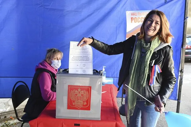 A woman who lives in Russia, from the Donetsk region, the territory controlled by a pro-Russia separatist government, holds her ballot during a referendum at a temporary accommodation facility in the Novocherkassk, Rostov-on-Don region of Russia, Saturday, September 24, 2022. Voting began Friday in four Moscow-held regions of Ukraine on referendums to become part of Russia. Polls also opened in Russia, where refugees from regions under Russian control can cast their votes. (Photo by AP Photo/Stringer)