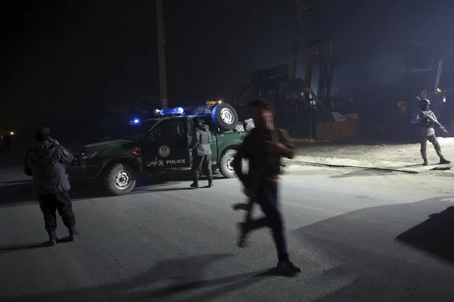 Policemen block the road near the site of a suicide attack in Kabul, Afghanistan, Monday, January 14, 2019. Afghan officials say multiple people were killed when a suicide bomber detonated a vehicle full of explosive in the capital Kabul on Monday. (Photo by Massoud Hossaini/AP Photo)