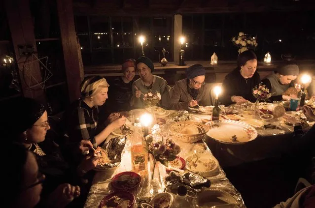 Ultra-orthodox Jewish women share a candle light diner to celebrate the Jewish ritual of “Sheva Brachot” (The seven blessings), also known as the wedding blessings, on February 17, 2016 in Kadita an unrecognised community village in northern Israel. The ritual in celebrate during a seven days period after a couple gets married. (Photo by Menahem Kahana/AFP Photo)