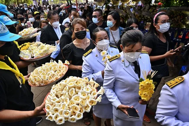 Mourners take funeral flowers to pay respects to the victims of the nursery mass shooting at Wat Rat Samakee temple in northeastern Nong Bua Lam Phu province on October 11, 2022. Victims of the nursery massacre were set to be cremated at specially built traditional pyres at temples on October 11, after the staggering death toll of the rampage overwhelmed local crematoriums. (Photo by LIllian Suwanrumpha/AFP Photo)