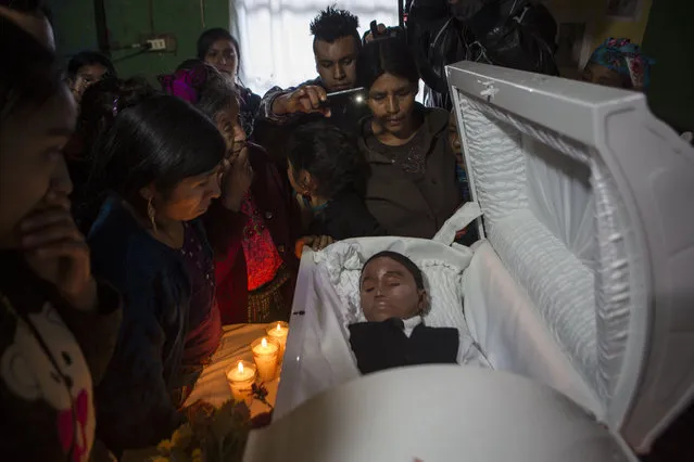 Family members pay their final respects to Felipe Gomez Alonzo in Yalambojoch, Guatemala, Saturday, January 26, 2019. The 8-year-old migrant boy died in U.S. custody at a New Mexico hospital on Christmas Eve. Felipe and his father were apprehended by the U.S. Border Patrol in mid-December. (Photo by Oliver de Ros/AP Photo)