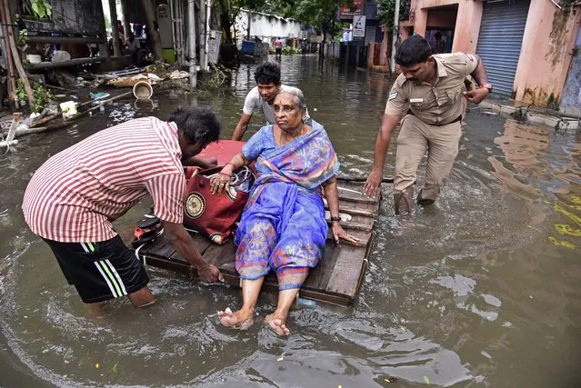 Volunteers and police personnel rescue an elderly woman from a flooded locality following heavy downpours during “Cyclone Michaung”, in Chennai, India, 06 December 2023. Cyclone Michaung made landfall near the town of Bapatla on the coast of Andhra Pradesh state on 05 December and later weakened to a cyclonic storm. Several areas in Chennai remained inundated and severely affected due to torrential rains and floods, with the region experiencing extremely heavy rainfall due to the influence of the cyclone. The police officials reported that at least 17 people died due to rain-related incidents in Chennai caused by Cyclone Michaung. (Photo by Idrees Mohammed/EPA)