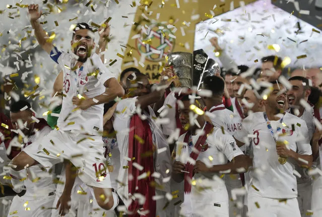 Qatar's forward Hasan Al Haydos, left, celebrates with teammates after winning the the AFC Asian Cup final match between Japan and Qatar in Zayed Sport City in Abu Dhabi, United Arab Emirates, Friday, February 1, 2019. (Photo by Hassan Ammar/AP Photo)