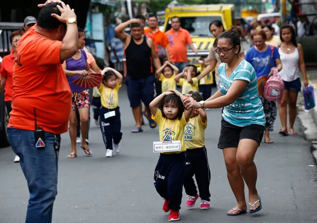 Village day care center pupils participate in evacuation measures during the third quarter Nationwide Earthquake Drill in Escopa 1 District in Quezon, Philippines, 16 August 2018. The country's National Disaster Risk Reduction and Management Council (NDRRMC) encourages the public to participate and learn emergency response protocols in order to react in a safe and orderly manner in the event of an actual disaster such as an earthquake. (Photo by Rolex Dela Pena/EPA/EFE)