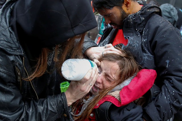 An activist demonstrating against U.S. President Donald Trump is helped after being hit by pepper spray on the sidelines of the inauguration in Washington, D.C. January 20, 2017. (Photo by Adrees Latif/Reuters)