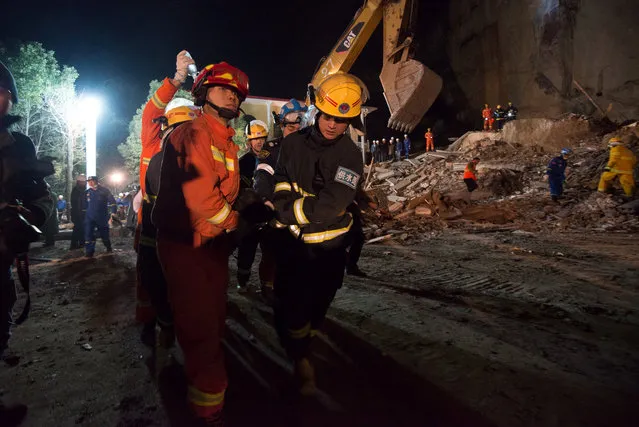 Rescuers carry a trapped person at a site of landslide near a hotel in Xiangyang, Hubei province, China, January 20, 2017. (Photo by Reuters/Stringer)