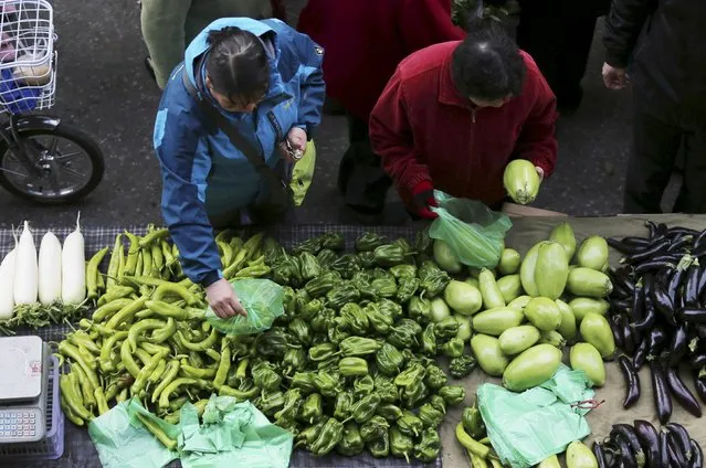 People select vegetables at a open-air morning market in Shenyang, Liaoning province April 10, 2015. China's consumer inflation stayed flat at 1.4 percent in March, while producer prices fell slightly less than projected, official data showed on Friday, keeping pressure on profit margins at Chinese companies as Beijing struggles to stimulate growth. (Photo by Reuters/Stringer)
