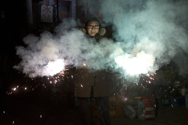A resident lets off sparklers on the eve of Lunar New Year in Beijing, China, Friday, January 27, 2017. (Photo by Ng Han Guan/AP Photo)