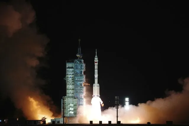 In this photo released by Xinhua News Agency, the crewed spaceship Shenzhou-13, atop a Long March-2F carrier rocket, is launched from the Jiuquan Satellite Launch Center in northwest China's Gobi Desert, October 16, 2021. (Photo by Li Gang/Xinhua via AP Photo)