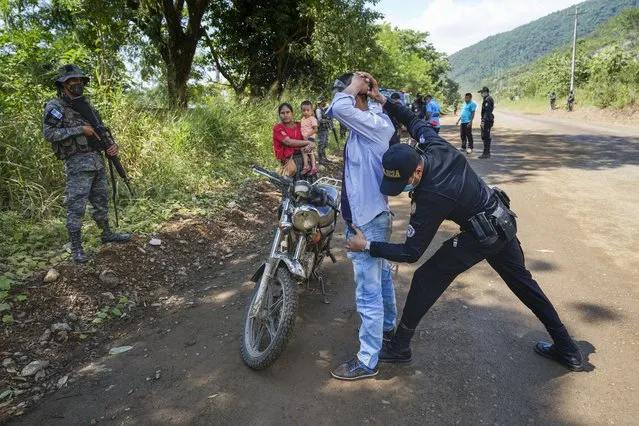 A man is frisked by police at a check point in El Estor in the northern coastal province of Izabal, Guatemala, Monday, October 25, 2021. The Guatemalan government has declared a month-long, dawn-to-dusk curfew and banned pubic gatherings following protests against a nickel mining project. (Photo by Moises Castillo/AP Photo)
