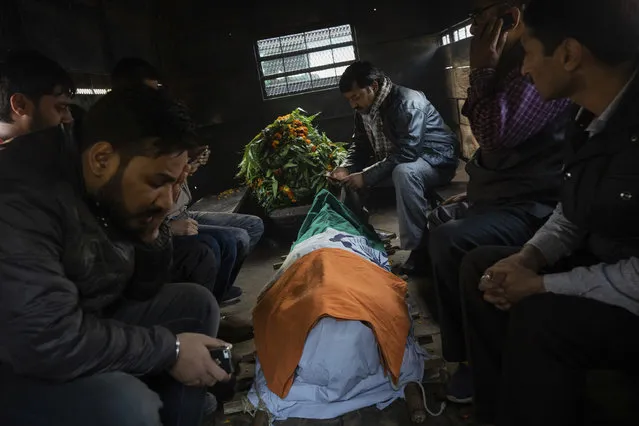 In this Tuesday, December 4, 2018 photo, relatives cry next to the body of police Inspector Subodh Kumar Singh in Chingarwathi, near Bulandshahr, in the northern Indian state of Uttar Pradesh. The previous day, Singh and another person were killed in the mob violence that began with accusations of cow slaughter in the area. (Photo by Bernat Armangue/AP Photo)