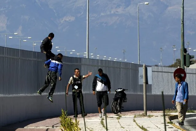 A security officer shouts at Afghan immigrants who have jumped over a fence at a ferry terminal in the western Greek town of Patras May 4, 2015. (Photo by Yannis Behrakis/Reuters)