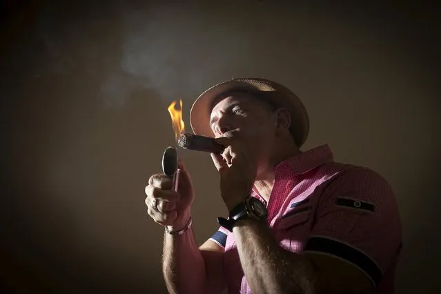 Owner of Guantanamera Cigars, Jose Montagne lights up a cigar as he poses for a photo in his store on the famed Calle Ocho (Eighth Street) in the Little Havana section of Miami, April 16, 2015. Montagne is one of more than a dozen cigar makers in the United States that Cuba's renowned state-owned tobacco company has tried to block from using names referring to the Communist-run island. (Photo by Carlo Allegri/Reuters)