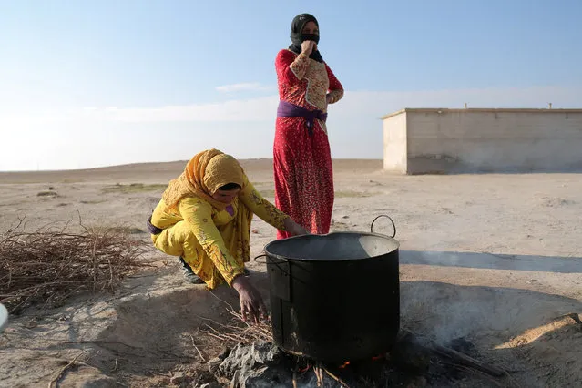 Residents of Bir Said village cook on a fire after their return to the village when Syrian Democratic Forces took control of the area from Islamic State militants in northern Raqqa province, Syria February 7, 2017. (Photo by Rodi Said/Reuters)