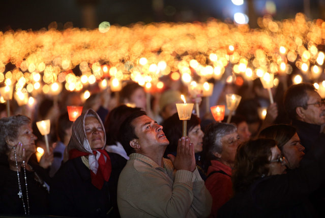Worshippers pray during a candle light vigil at the Our Lady of Fatima shrine, in Fatima, central Portugal, Tuesday, May 12, 2015. (Photo by Francisco Seco/AP Photo)