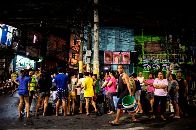 Residents of Addition Hills in Madaluyong City, Manila, queue to recieve water distributed on water tank truck and fire trucks on March 15, 2019. Manila has been hit by its worst water shortage in years, leaving bucket-bearing families to wait hours for a fill up from tanker trucks and some hospitals to turn away less urgent cases. (Photo by Noel Celis/AFP Photo)