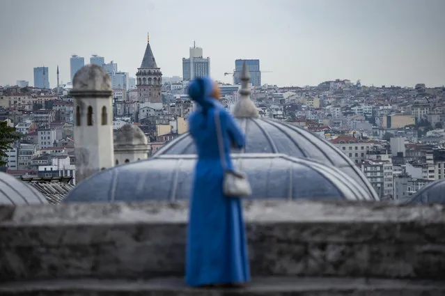 A woman looks on from the terrace of the Suleymaniye mosque after Eid al-Fitr prayers at the Suleymaniye mosque on June 4, 2019 in Istanbul. Muslims throughout the world are marking the month of Ramadan, the holiest month in the Islamic calendar during which devotees fast from dawn till dusk. (Photo by Yasin Akgul/AFP Photo)