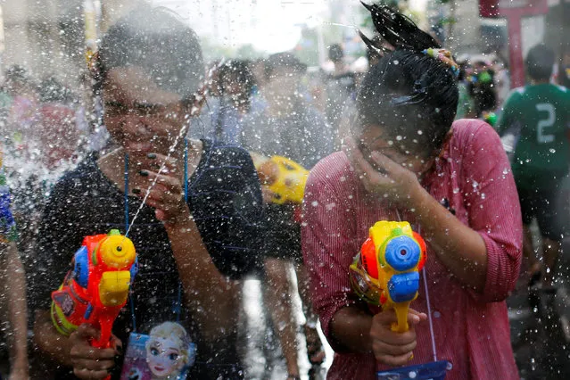 Revellers react during a water fight at Songkran Festival celebrations in Bangkok April 13, 2016. (Photo by Jorge Silva/Reuters)