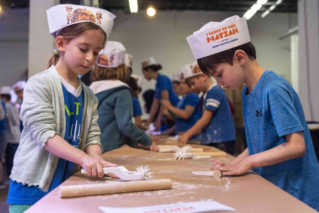 First graders from Milton Gottesman Jewish Day School of the Nation's Capitol, make matzah during a “Matzah Factory” field trip to the JCrafts Center for Jewish Life and Tradition in Rockville, Md., Thursday, April 18, 2024, ahead of the Passover holiday which begins next Monday evening. To be kosher for Passover the dough has to be prepared and cooked all within 18 minutes and not allowed to rise. (Photo by Jacquelyn Martin/AP Photo)