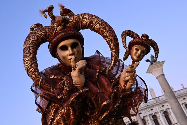 A masked reveller wearing traditional carnival costumes poses during the carnival in Venice on February 11, 2023. (Photo by Miguel Medina/AFP Photo)