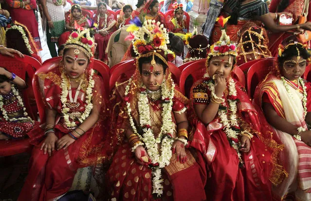 Young girls yet to attain puberty are dressed up as living goddesses before being worshipped as “kumari” or virgin during the Bengali Hindu festival of Basanti Durga puja performed in the spring in Kolkata, India, Friday, April 15, 2016. Worshipping kumaris or virgins on the ninth day or navami of the festival is an important ritual when they are worshipped as the base power of all creation. The more popular form of Durga festival is performed in autumn when the Hindu mythical figure Rama is said to have called upon goddess Durga to seek her blessings to defeat the evil character Ravana. (Photo by Bikas Das/AP Photo)