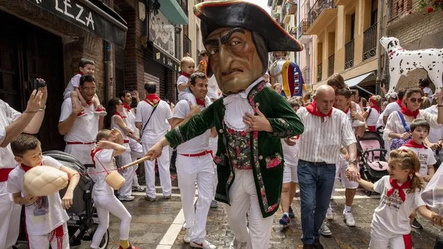 Caravinagre “Vinegar face” kiliki hits with a sponge to a boy during the Comparsa de Gigantes y Cabezudos, or Giants and Big Heads parade on the third day of the San Fermin Running of the Bulls festival on July 08, 2019 in Pamplona, Spain. The annual Fiesta de San Fermin, made famous by the 1926 novel of US writer Ernest Hemmingway entitled “The Sun Also Rises”, involves the daily running of the bulls through the historic heart of Pamplona to the bull ring. (Photo by Pablo Blazquez Dominguez/Getty Images)