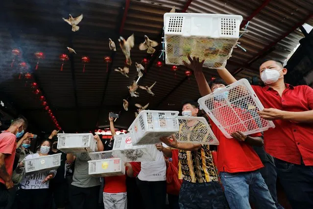 Worshippers wearing protective masks release birds for good luck during the Chinese Lunar New Year of the Tiger celebrations at the Dharma Bhakti temple in Jakarta, Indonesia, February 1, 2022. (Photo by Willy Kurniawan/Reuters)