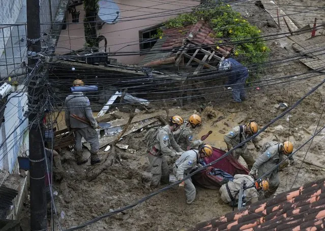 Rescue workers carry the body of a landslide victim in Petropolis, Brazil, Wednesday, February 16, 2022. (Photo by Silvia Izquierdo/AP Photo)