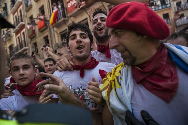 Revelers try to walk in the street  during the launch of the “Chupinazo” rocket, to celebrate the official opening of the 2015 San Fermin Fiestas, in Pamplona, northern Spain, Monday, July 6, 2015. (Photo by Alvaro Barrientos/AP Photo)