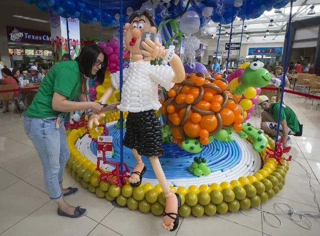 Designers make a final touch on their art work during an international festival of air balloons design in Almaty, Kazakhstan, July 9, 2015. (Photo by Shamil Zhumatov/Reuters)