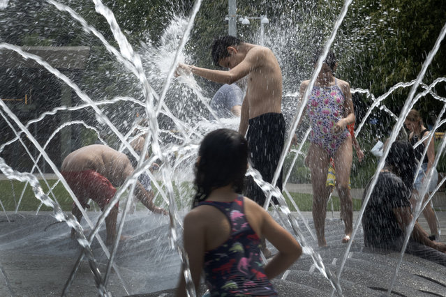People cool off in the fountain at Polk Brothers Park at Navy Pier as temperatures climbed above 90 degrees Fahrenheit on June 19, 2024 in Chicago, Illinois. A heat wave has brought record warm temperatures to much of the Midwest and Northeast areas of the country this week. (Photo by Scott Olson/Getty Images)