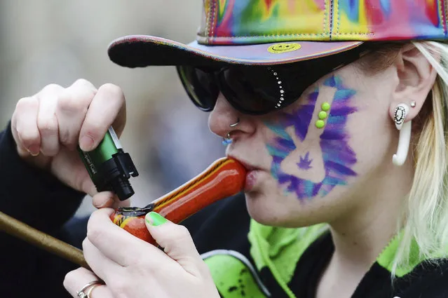 A woman smokes a pipe during a 4/20 rally on Parliament Hill in Ottawa, on Thursday, April 20, 2017. (Photo by Sean Kilpatrick/The Canadian Press via AP Photo)