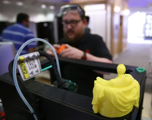 TechShop representative Andy Leer maintains a MakerBot Replicator 2 desktop 3D printer at the GE Garage in Washington March 20, 2014. GE Garage space is open from March 24 to April 9 in Washington and offers the chance to explore and learn about how technology is changing the way things are built today. (Photo by Gary Cameron/Reuters)