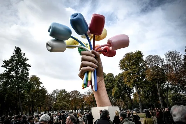 Spectators attend the unveiling of the “Bouquet of Tulips” sculpture by US artist Jeff Koons near The Petit Palais Museum in Paris on October 4, 2019. A controversial work by American pop artist Jeff Koons, aiming to symbolise US solidarity with France in the wake of the 2015 jihadist attacks. (Photo by Stephane De Sakutin/AFP Photo)