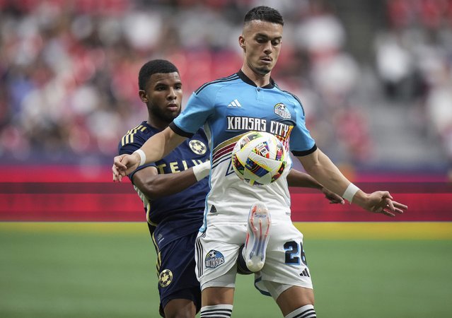 Vancouver Whitecaps' Pedro Vite, left, kicks Sporting Kansas City's Erik Thommy between his legs as they vie for the ball during the second half of an MLS soccer match in Vancouver, British Columbia, Wednesday, July 17, 2024. (Photo by Darryl Dyck/The Canadian Press via AP Photo)