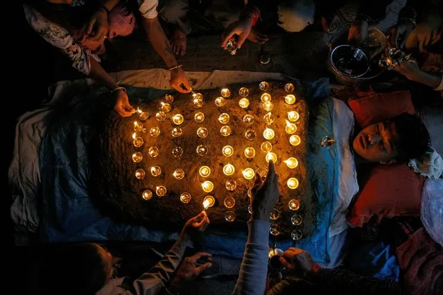 A devotee lies covered with oil lamps placed by other devotees while offering prayers as part of a ritual during “Dashain”, a Hindu religious festival, in Bhaktapur, Nepal, October 8, 2019. (Photo by Monika Deupala/Reuters)