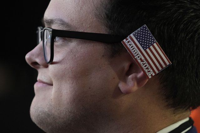 A delegate wearing a small American flag on his ear watches as Republican presidential candidate and former president, Donald Trump, speaks during the final day of the Republican National Convention Thursday, July 18, 2024, in Milwaukee. (Photo by Paul Sancya/AP Photo)