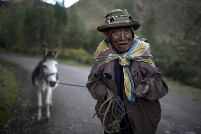 Cirilo Pacco, 80, asks for a tip after being photographed, in Paru Paru community, Cusco region, Peru, Thursday, May 26, 2016. (Photo by Rodrigo Abd/AP Photo)